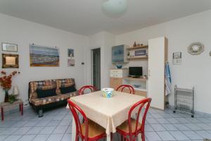 a living room with a table and chairs and a couch at N043 - Numana, bilocale con giardino in Sirolo