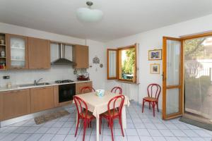 a kitchen with a table and red chairs in it at N043 - Numana, bilocale con giardino in Sirolo