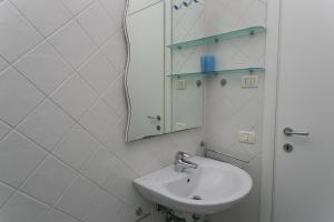 a white bathroom with a sink and a mirror at N043 - Numana, bilocale con giardino in Sirolo +10 photos