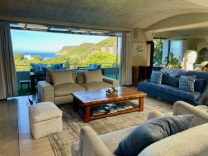 a living room with couches and a table at Beach End Plettenberg Bay in Plettenberg Bay
