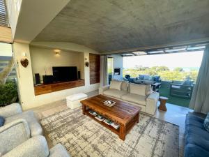 a living room with a couch and a coffee table at Beach End Plettenberg Bay in Plettenberg Bay