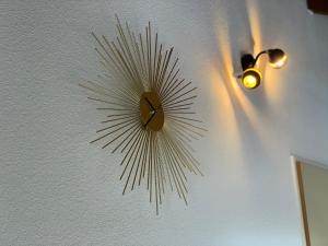 a clock hanging on a wall with a light at Breathtaking Waterfall Apartment nr 3 in Lauterbrunnen +9 photos