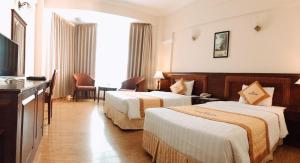 Habitación de hotel con 2 camas y TV en Saigon Kimlien Resort Cualo en Cửa Lò