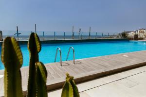 a swimming pool with a cactus in front of it at Hotel Cristina by Tigotan Las Palmas - Adults Only in Las Palmas de Gran Canaria