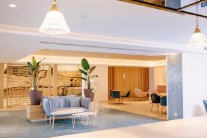 a lobby with a blue couch and chairs at Hotel Cristina by Tigotan Las Palmas - Adults Only in Las Palmas de Gran Canaria