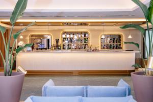 a bar in a restaurant with blue couches at Hotel Cristina by Tigotan Las Palmas - Adults Only in Las Palmas de Gran Canaria