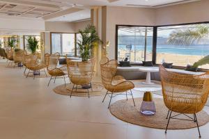 a lobby with chairs and tables and a beach at Hotel Cristina by Tigotan Las Palmas - Adults Only in Las Palmas de Gran Canaria