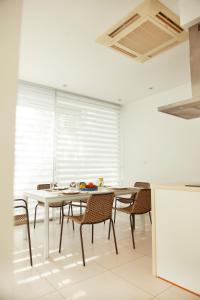a dining room with a white table and chairs at Touch Blue Residences in Larnaca