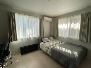 a bedroom with a bed and two large windows at Evergreen Shinjuku #303 MM7 in Tokyo