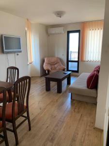 een woonkamer met een bank en een tafel bij Sozopol Dreams - Apartment №41 in Sozopol
