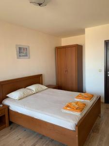 een slaapkamer met een bed en een houten kast bij Sozopol Dreams - Apartment №41 in Sozopol