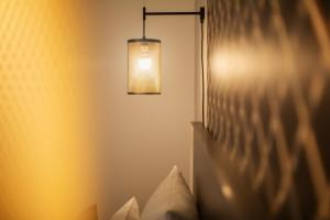 um quarto com uma cama com uma luz na parede em the niu Mesh - Apartments em Stuttgart