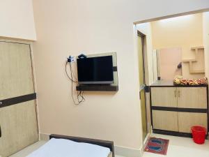 a room with a flat screen tv on the wall at Hotel Nishi Pvt ltd in Balasore