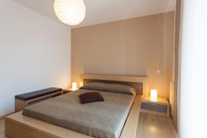 a bedroom with a bed with two lights on it at Apartments Banić in Poreč