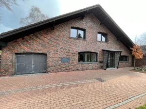 ein Backsteinhaus mit zwei Fenstern und einer Backsteineinfahrt in der Unterkunft Haus Wunschlos Auf Aderich in Monschau
