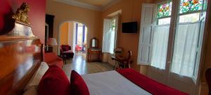 a bedroom with a bed with red pillows and a window at Hotel Noucentista in Sitges