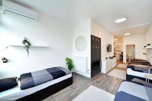 a bedroom with two beds and a living room at Apartments Dubec in Sesvete