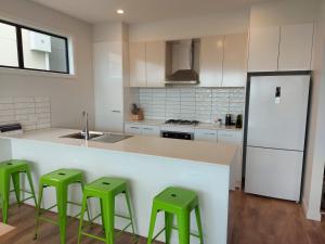 a kitchen with green stools at a kitchen counter at Waterline Property Portarlington in Portarlington
