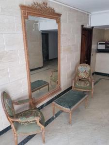 a mirror and two chairs and a chair and a stool at The LOTUS in Hurghada