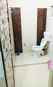 a bathroom with a toilet in a shower stall at Hotel Nishi in Balasore