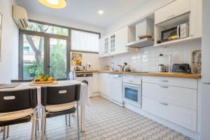 a kitchen with white cabinets and a table and chairs at Casa Sunny in Port de Soller