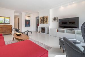 a living room with a red couch and a tv at Casa Sunny in Port de Soller