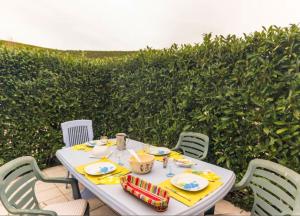 uma mesa branca com quatro cadeiras e uma mesa com guardanapos amarelos em Maison de 2 chambres avec jardin clos et wifi a Criel sur Mer em Criel-sur-Mer