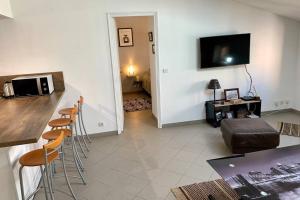 a living room with a counter and a bar with chairs at Bel appartement 4 étoiles Centre Historique Toulon in Toulon