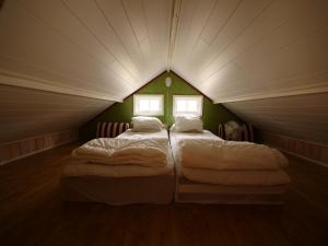 two beds in a small room with two windows at Rolsmo Norregård 16 in Linneryd