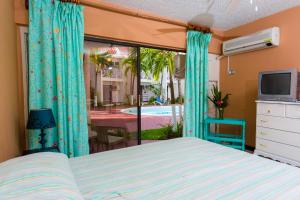 a bedroom with a bed and a television and a patio at Villa Criss in Ocho Rios
