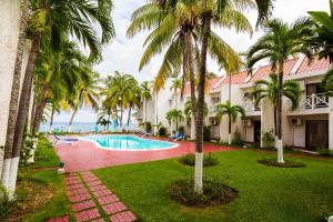 an exterior view of a resort with a swimming pool and palm trees at Villa Criss in Ocho Rios