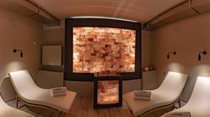 a room with two white chairs and a brick wall at Hotel Miramare & Spa in Sestri Levante