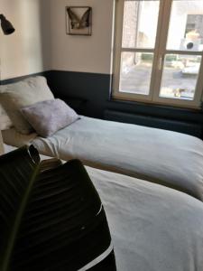 two beds in a room with a window at Milk and cookies in Venlo