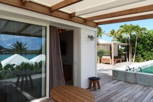 an outdoor patio with sliding glass doors and a deck at Le Sereno in Gustavia
