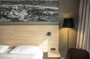 a bedroom with a bed and a picture of a city at Park Inn by Radisson Vilnius Airport Hotel & Conference Centre in Vilnius