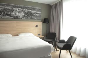 a hotel room with a bed and two chairs at Park Inn by Radisson Vilnius Airport Hotel & Conference Centre in Vilnius