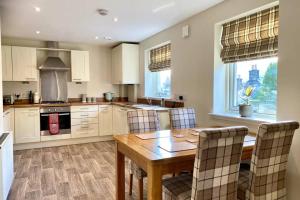 a kitchen with a wooden table and chairs at Beautiful 2 Bedroom, 2 Bathroom Flat with Parking. in Pitlochry
