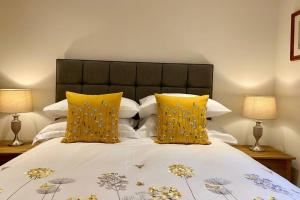a bedroom with a bed with yellow pillows at Beautiful 2 Bedroom, 2 Bathroom Flat with Parking. in Pitlochry