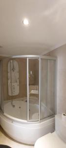 a bathroom with a large glass shower with a tub at VILLA CASTLE INN in Antalya