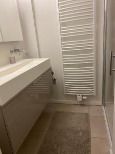une salle de bain avec un lavabo et une douche avec un miroir dans l'établissement Apartment Zin in Zee, à Knokke-Heist 25 autres photos