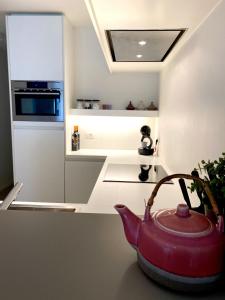 a kitchen with a red tea pot on a counter at Apartment Zin in Zee in Knokke-Heist