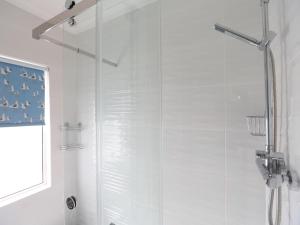 a bathroom with a shower with a glass door at 4 The Elms in Salcombe