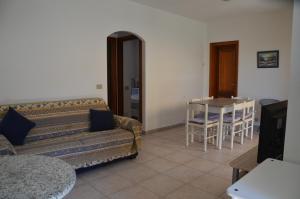 a living room with a couch and a table at Villetta con giardino in contesto riservato non lontana dal mare BEL01 in Agrustos