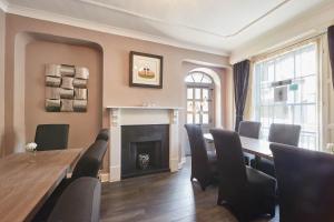 a dining room with a table and chairs and a fireplace at Host & Stay - Rosedale House in Richmond