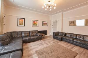 a living room with a leather couch and a table at Host & Stay - Rosedale House in Richmond