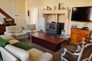 un salon avec un canapé et une cheminée dans l'établissement L'Armance - Magnifique Maison typique morvan avec piscine, à Nuars