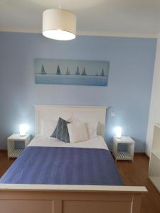 ein Schlafzimmer mit einem Bett und zwei Segelbooten an der Wand in der Unterkunft FX Pena in Funchal