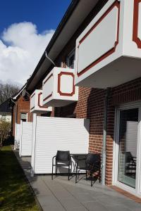 un grupo de sillas sentadas fuera de una casa en Landhaus Braband Studios - Rugenbargsweg 17, en Cuxhaven