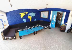 een kamer met een blauwe muur met een bank en een tafel bij The Lazy Monkey Hostel & Apartments in Zadar