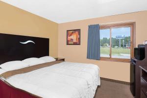 a bedroom with a large bed and a window at Super 8 by Wyndham Sheboygan WI in Sheboygan
